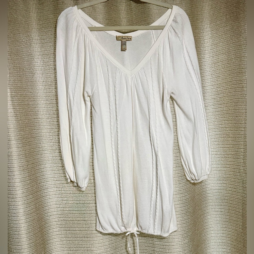 Lightweight white long-sleeve V-neck pintuck top with a tie-front hem.